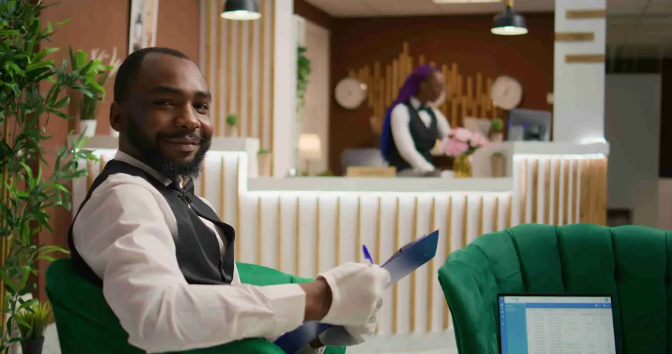 Hotel porter reading guest details in a hotel lobby