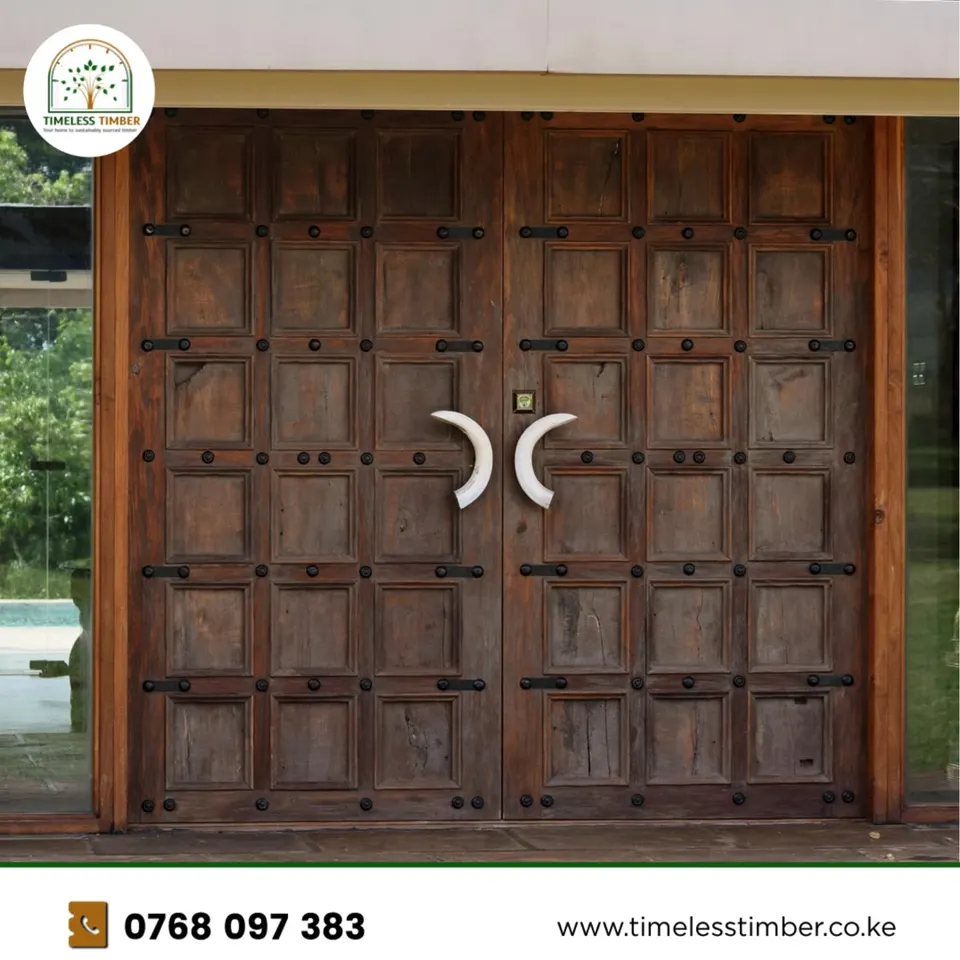 Carved hardwood double doors with iron studs at a house entrance